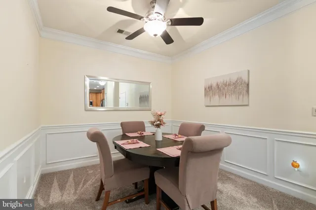 a view of a dining room with furniture and a chandelier fan