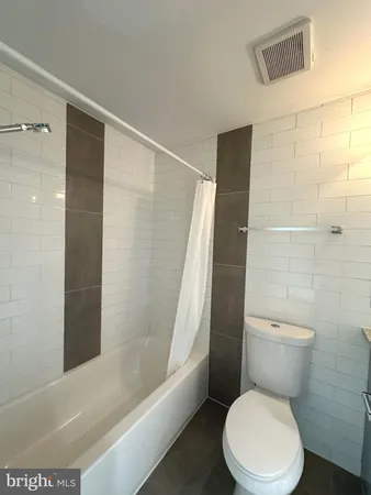 a white toilet sitting next to a bathtub