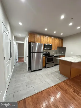 a kitchen with stainless steel appliances granite countertop a refrigerator and a stove