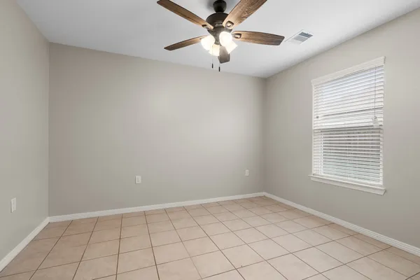 an empty room with windows and fan