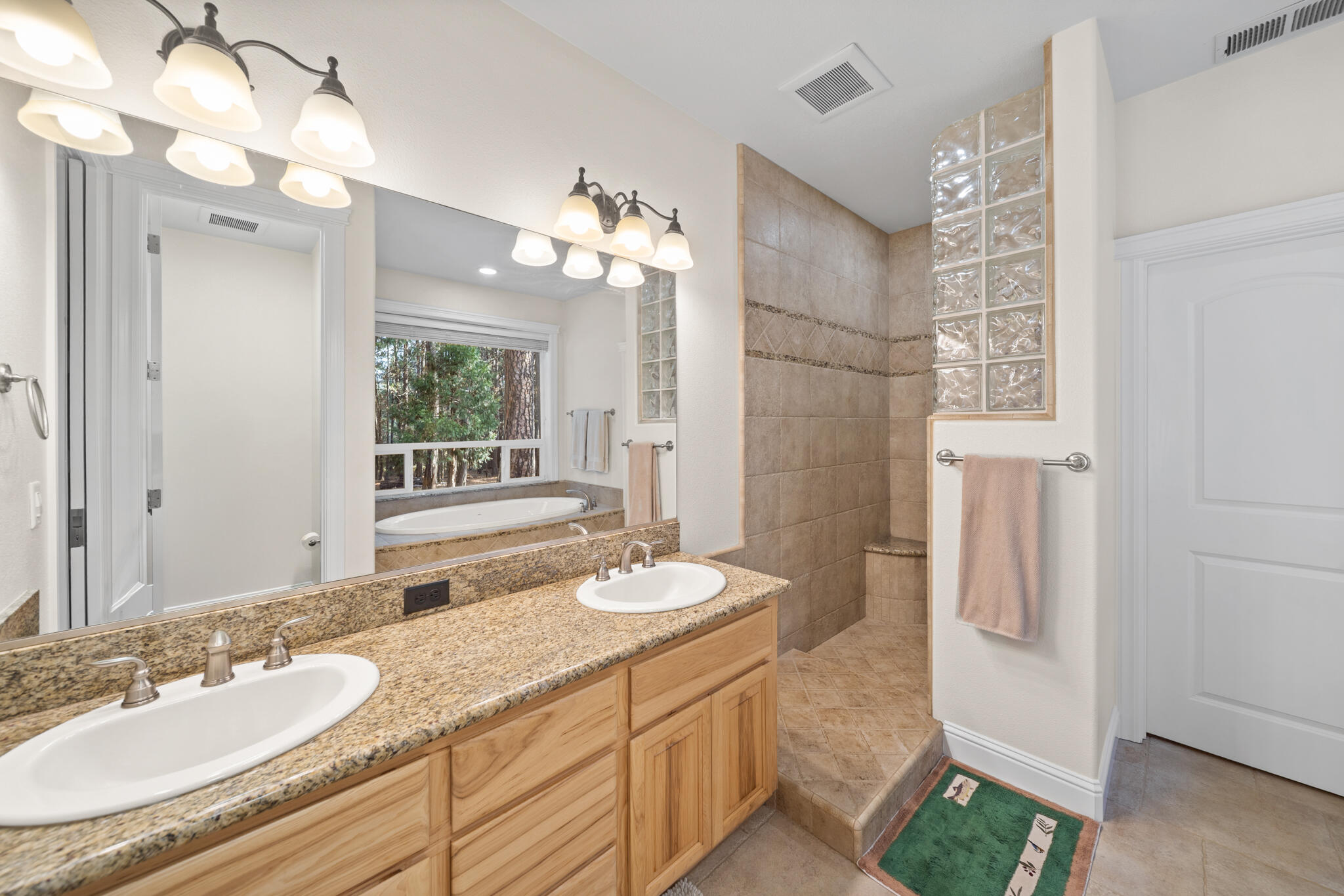 7795 Eastmoore Road Shingletown, CA 96088 - Photo 21 of 61 a bathroom with a granite countertop double vanity sink a mirror and a shower
