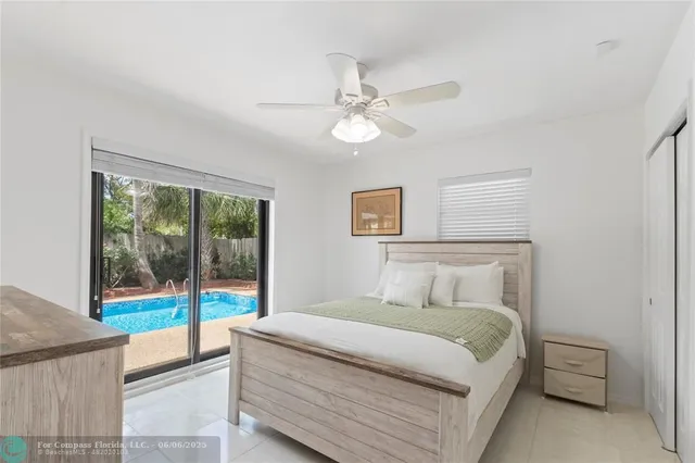 a bedroom with a balcony outdoor space and a ceiling fan