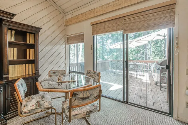 a dining room with furniture and a floor to ceiling window