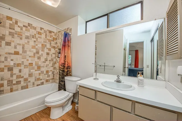 a bathroom with a sink a toilet and shower curtain