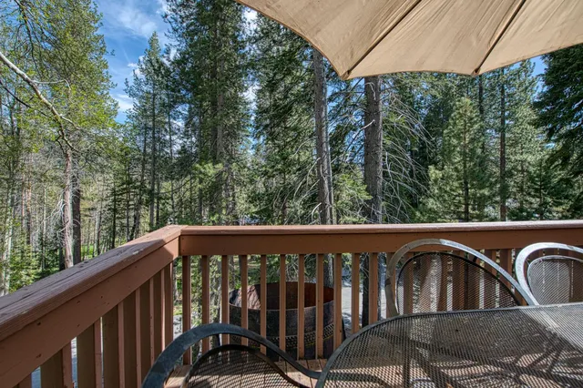 a view of a roof deck with potted plants and wooden fence
