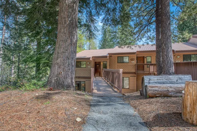 a view of a house with a tree next to a yard
