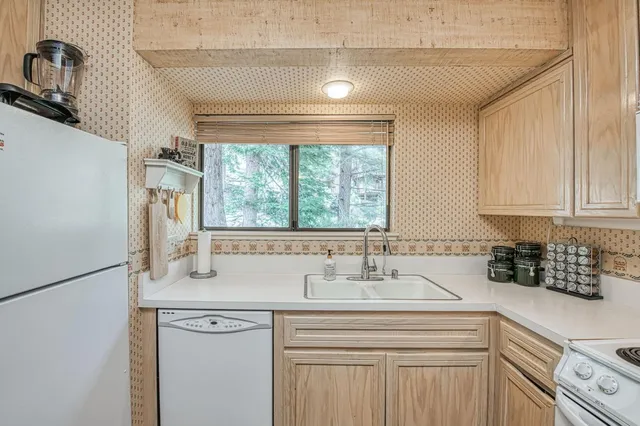 a kitchen with a sink cabinets appliances and a window