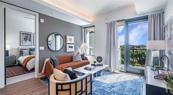 a living room with furniture a flat screen tv and a large window