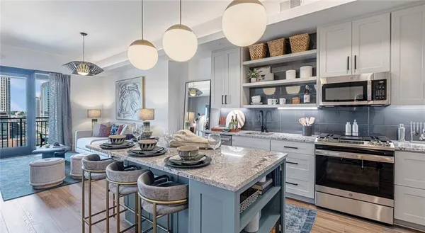 a kitchen with a stove cabinets a dining table and chairs
