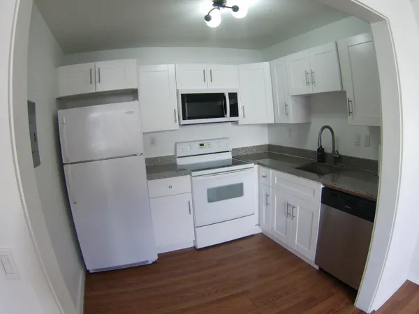 a kitchen with white cabinets sink and white appliances