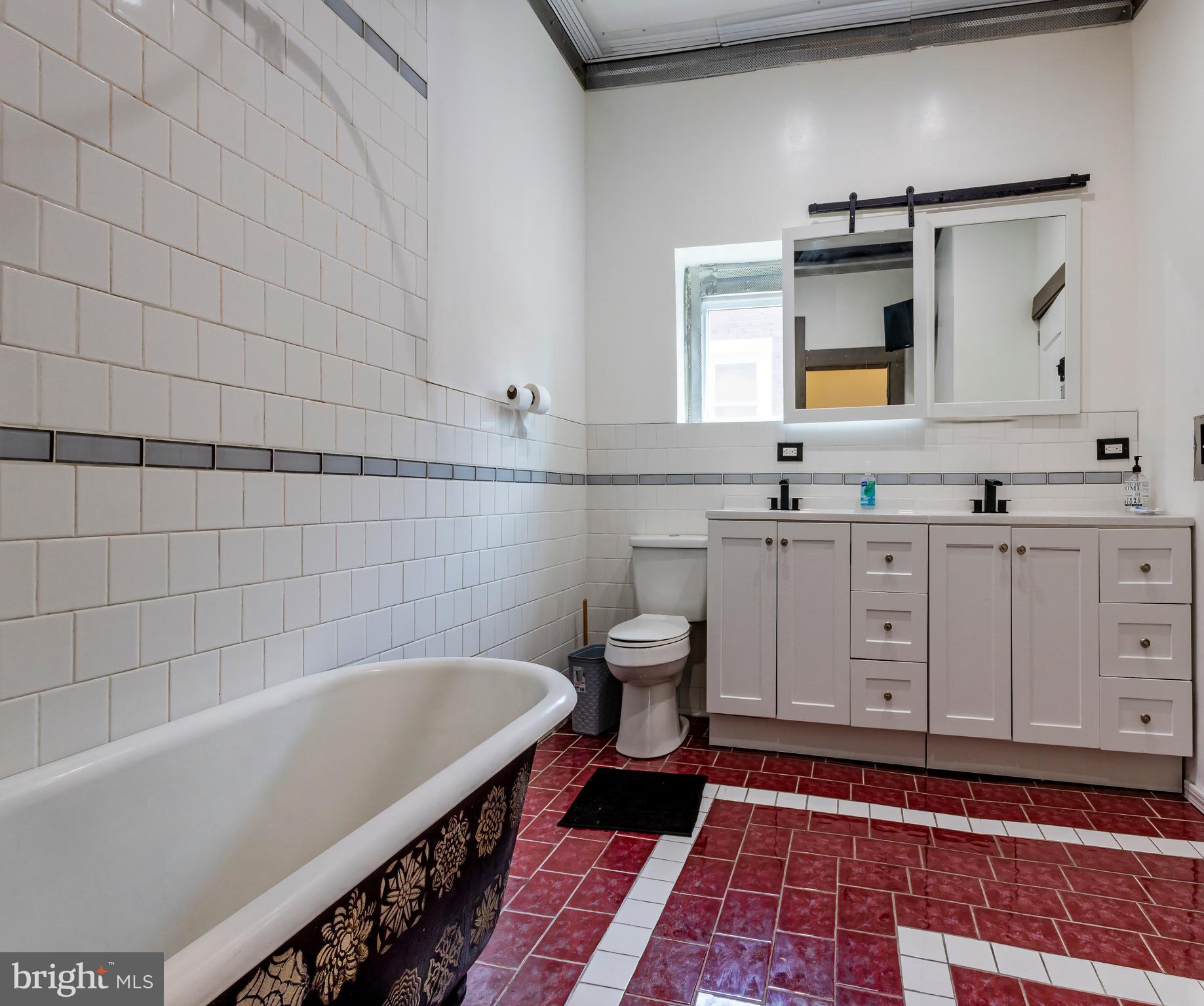 424 State Street Camden, NJ 08102 - Photo 27 of 36 a bathroom with a bathtub a sink a toilet a mirror and vanity