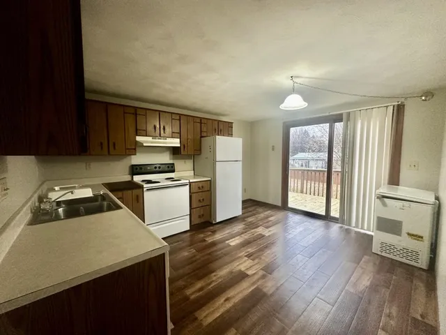 a kitchen with granite countertop a refrigerator stove top oven and sink