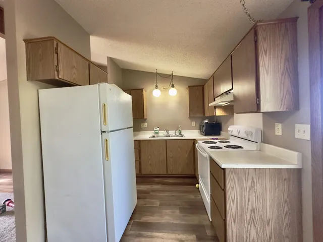 a kitchen with a refrigerator a stove top oven a sink and dishwasher