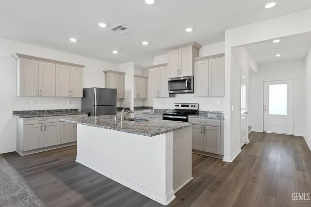 a kitchen with appliances a sink and cabinets