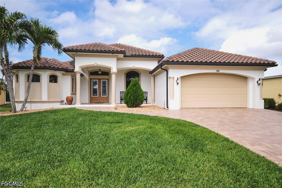 5306 Southwest 27th Place Cape Coral, FL 33914 - Photo 1 of 50 a front view of a house with a garden