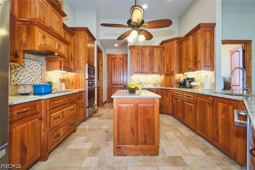 5306 Southwest 27th Place Cape Coral, FL 33914 - Photo 12 of 50 a large kitchen with stainless steel appliances a counter space a sink a window and cabinets