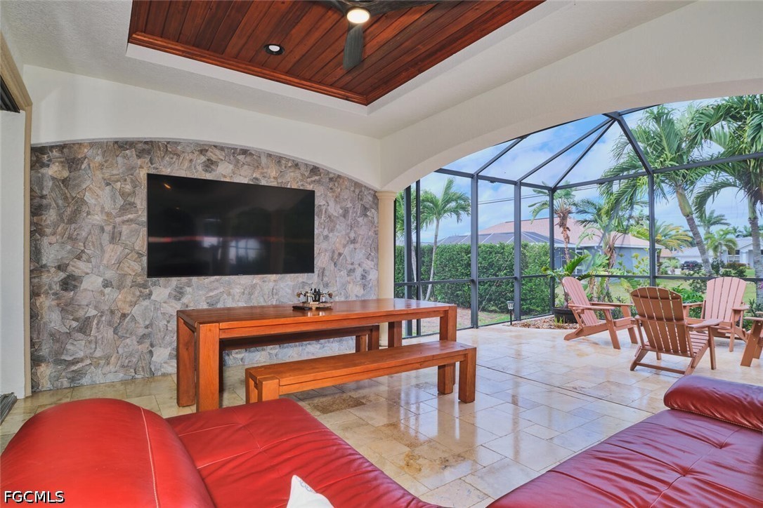 5306 Southwest 27th Place Cape Coral, FL 33914 - Photo 40 of 50 a living room with a fireplace a flat screen tv and a floor to ceiling window
