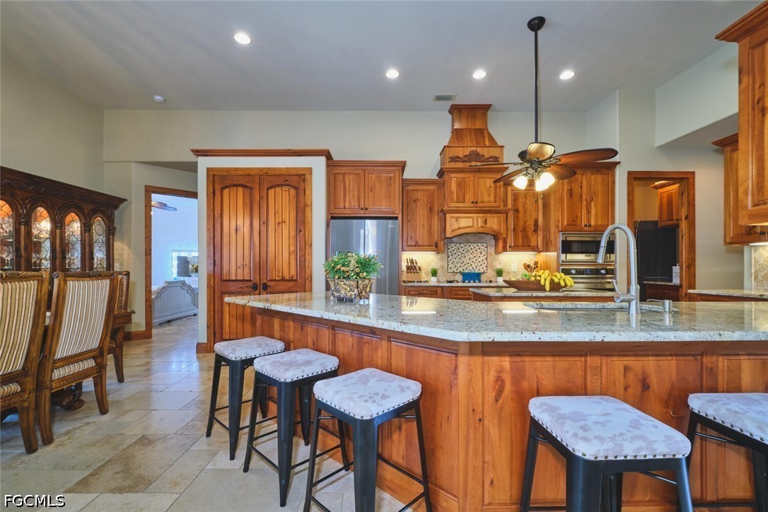 5306 Southwest 27th Place Cape Coral, FL 33914 - Photo 8 of 50 a kitchen with stainless steel appliances granite countertop table chairs and a large window