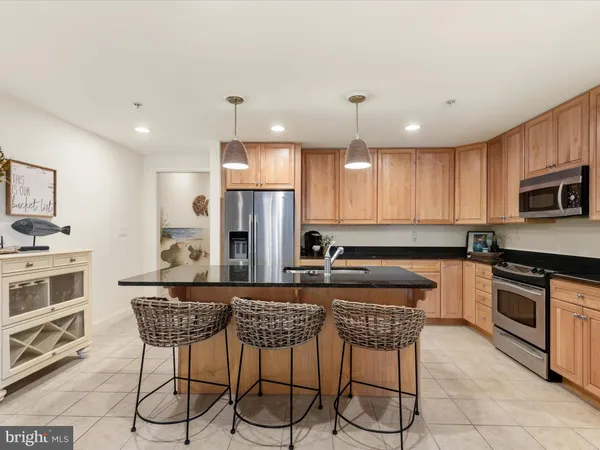 a kitchen with kitchen island granite countertop a stove sink and refrigerator