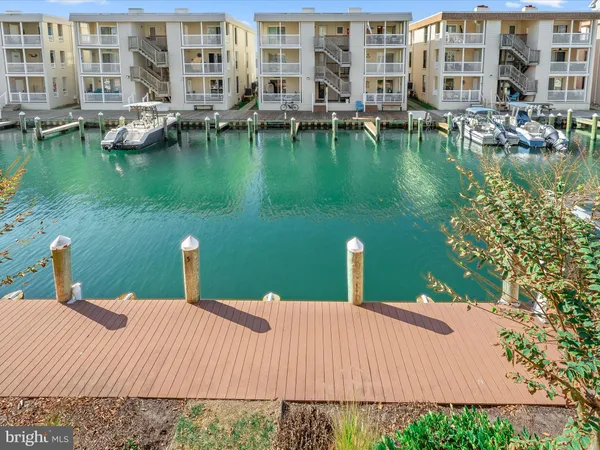 a view of a kitchen with kitchen island a sink wooden floor and a counter top space