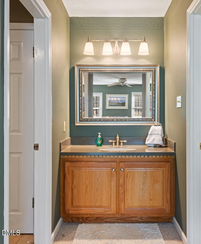 1832 Jimmie Kerr Road Haw River, NC 27258 - Photo 21 of 39 a bathroom with a granite countertop sink a mirror and a vanity