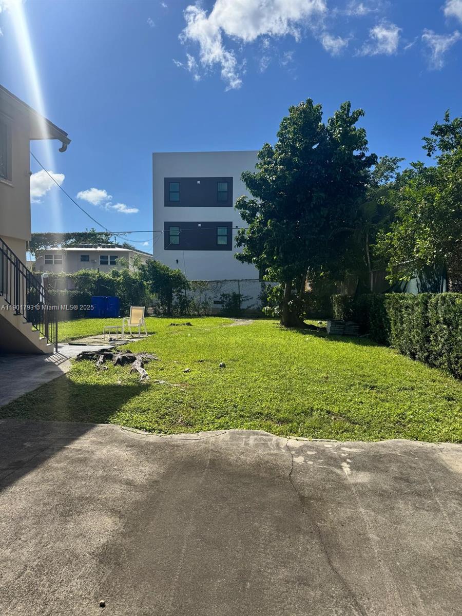 1036 Northwest 3rd Street, Unit 1 Miami, FL 33128 - Photo 19 of 22 a view of a house with a swimming pool and a yard