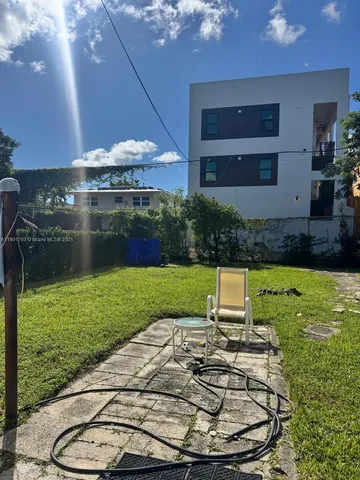 a backyard of a house with yard table and chairs