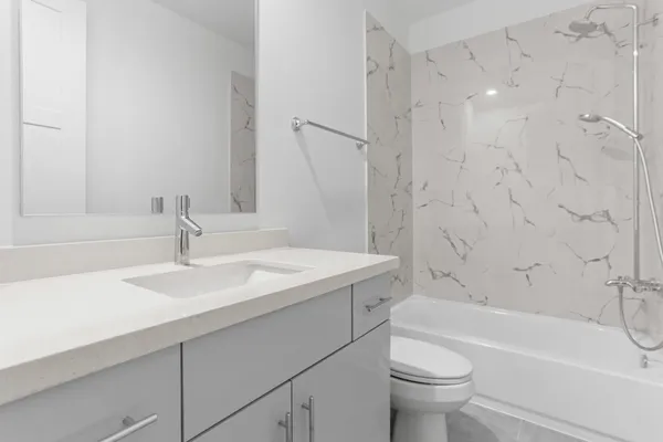 a bathroom with a sink toilet vanity and shower