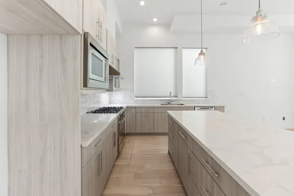 a kitchen with stainless steel appliances sink a stove and cabinets