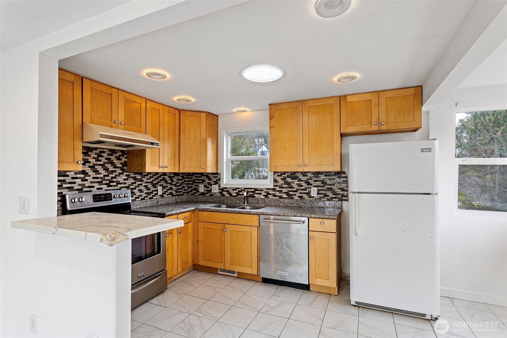 1901 South Plum Street Seattle, WA 98144 - Photo 4 of 14 a kitchen with stainless steel appliances granite countertop a refrigerator a sink dishwasher and white cabinets with wooden floor