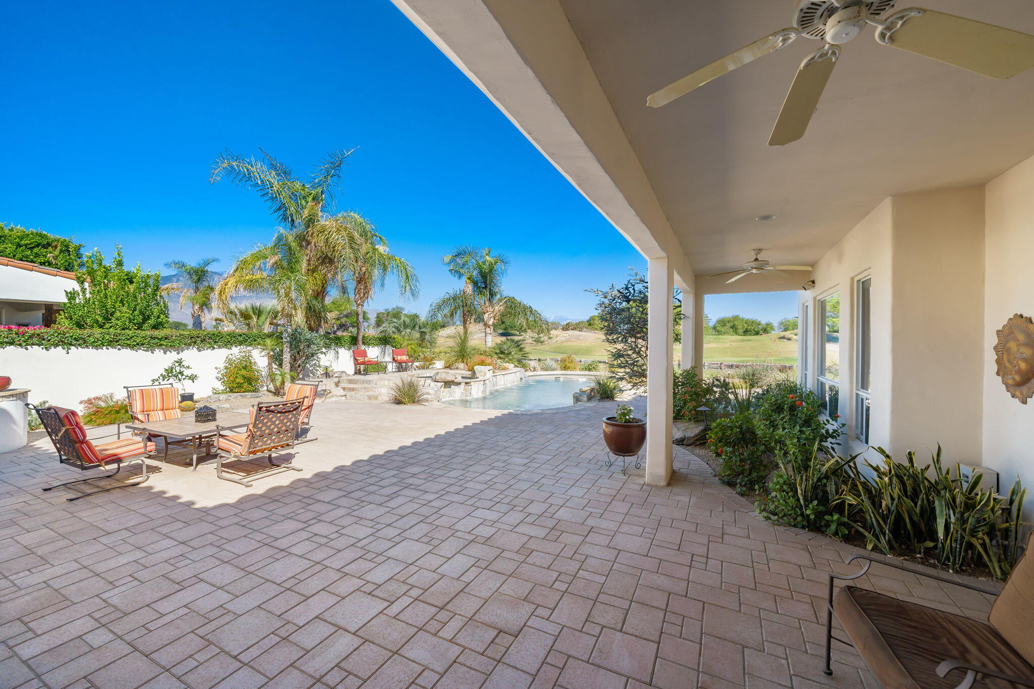 372 Loch Lomond Road Rancho Mirage, CA 92270 - Photo 31 of 51 a view of a patio with dining table and chairs potted plants