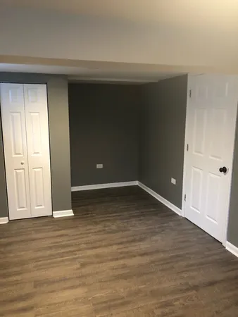 a view of an empty room with wooden floor and entryway