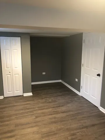 a view of an empty room with wooden floor and entryway