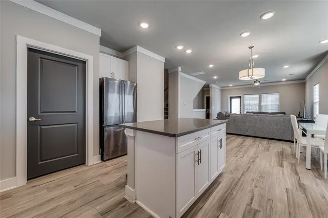 a kitchen with stainless steel appliances granite countertop a kitchen island a hardwood floor and a sink