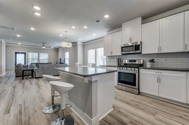 a kitchen with stainless steel appliances kitchen island granite countertop a sink and cabinets