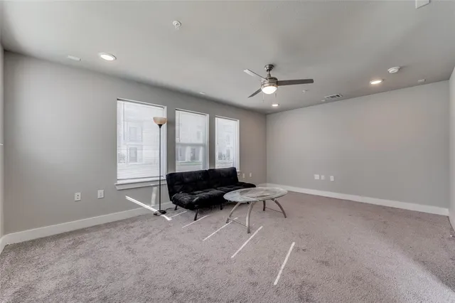 a living room with furniture and a ceiling fan