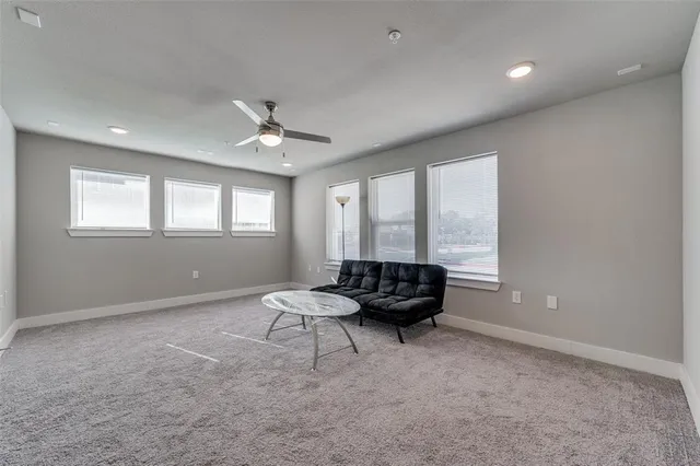 a living room with furniture and a ceiling fan