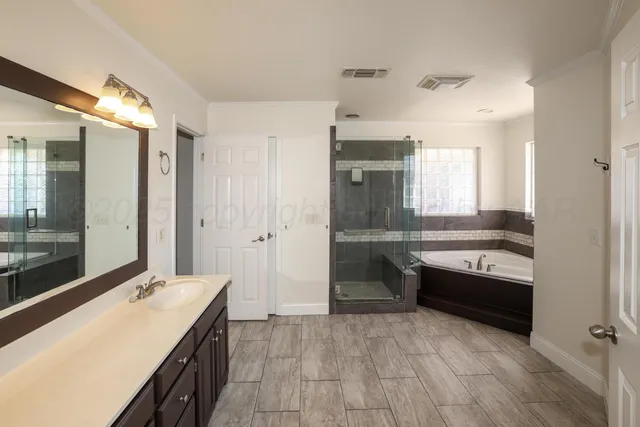 a bathroom with a sink and mirror with bathtub