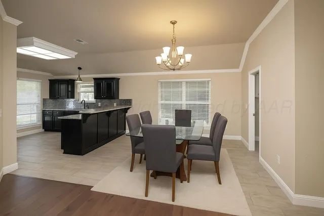 a view of a dining room with furniture a chandelier and wooden floor