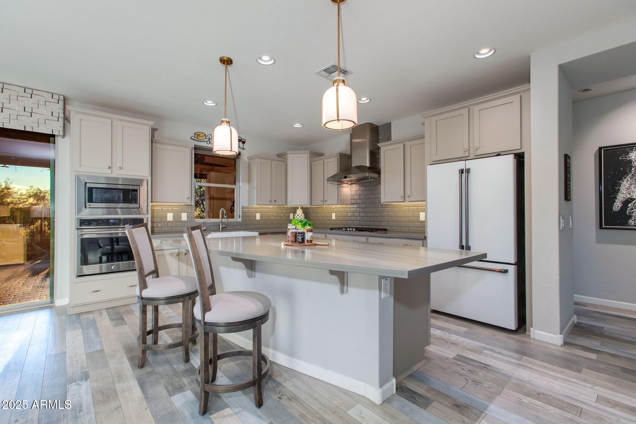 3800 Gold Ridge Road Wickenburg, AZ 85390 - Photo 11 of 51 a kitchen with cabinets a counter space stainless steel appliances and wooden floor
