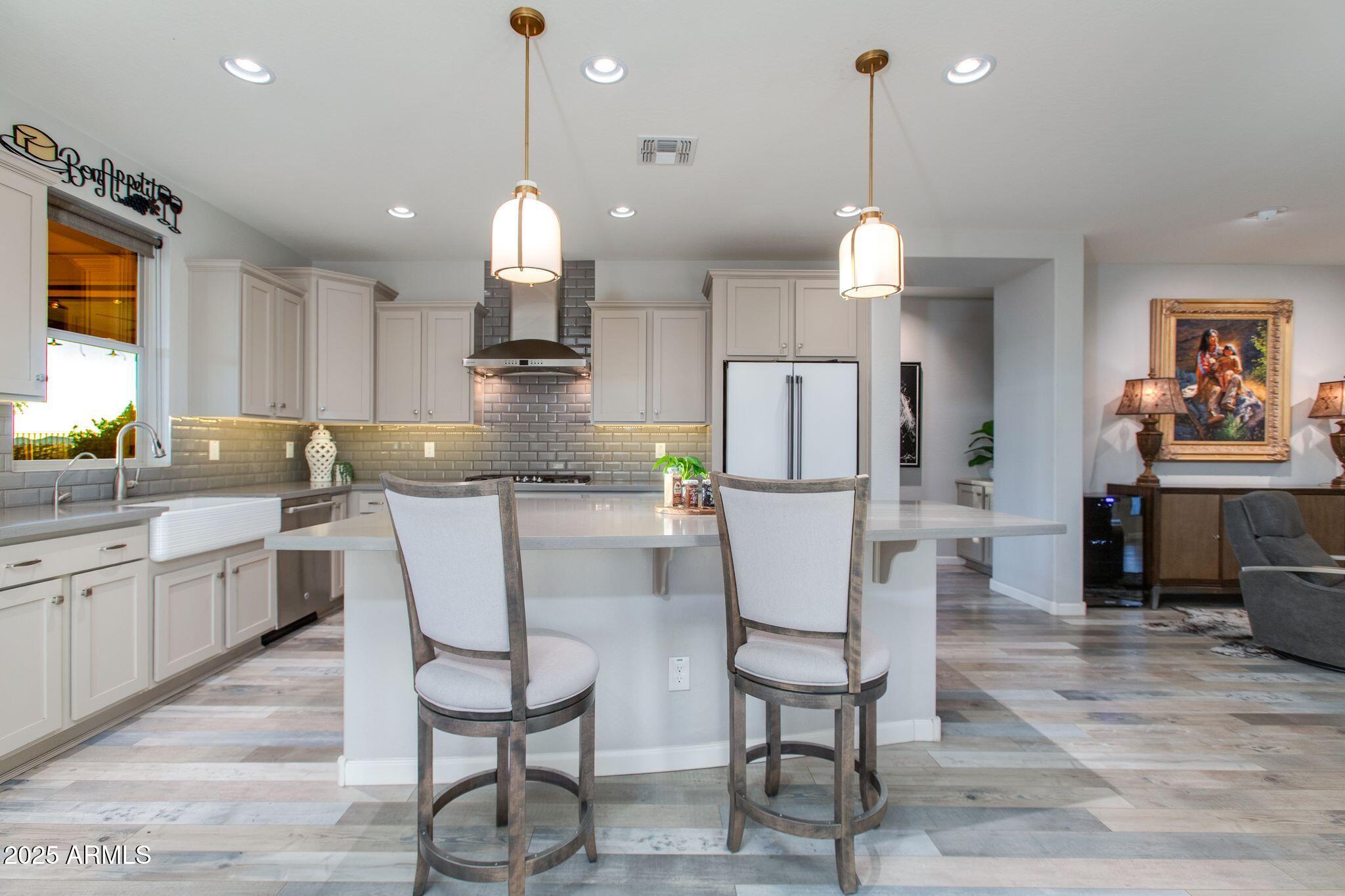 3800 Gold Ridge Road Wickenburg, AZ 85390 - Photo 12 of 51 a kitchen with stainless steel appliances kitchen island granite countertop a dining table chairs and white cabinets