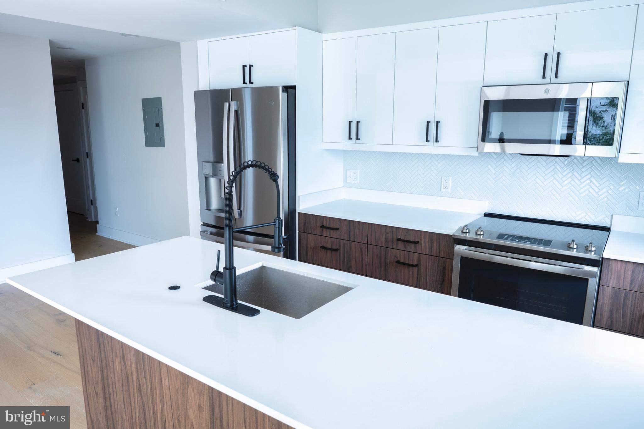 919 12th Street Northeast, Unit A301 Washington, DC 20002 - Photo 14 of 28 a kitchen with stainless steel appliances a sink stove and refrigerator