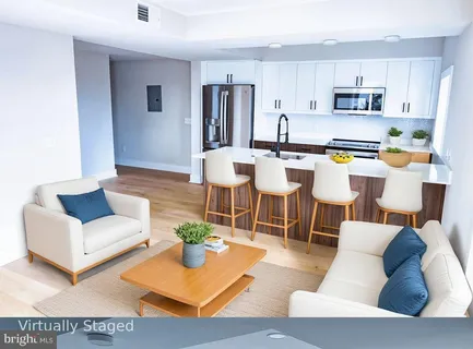 a living room with stainless steel appliances kitchen island granite countertop a couch and a view living room