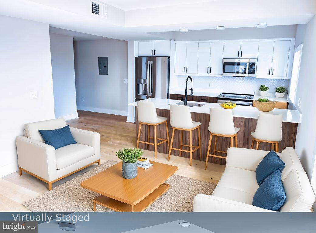 919 12th Street Northeast, Unit A301 Washington, DC 20002 - Photo 2 of 28 a living room with stainless steel appliances kitchen island granite countertop a couch and a view living room