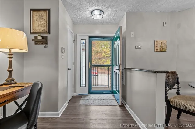 a view of a hallway with wooden floor and furniture