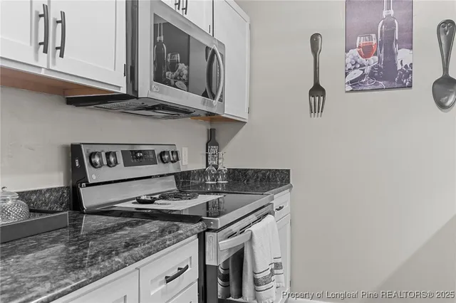 a kitchen with stainless steel appliances granite countertop a sink stove and cabinets