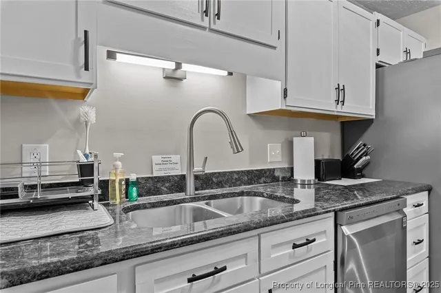 a kitchen with granite countertop a sink stainless steel appliances and cabinets