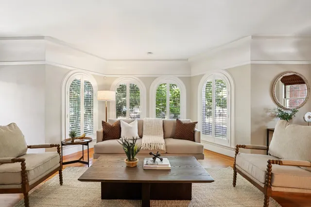 a dining room with furniture a large window and wooden floor