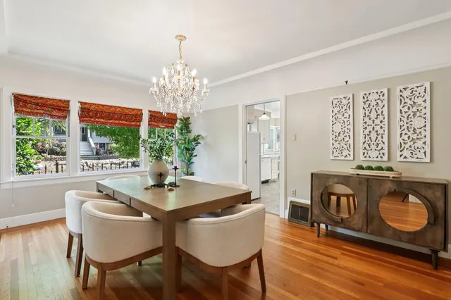 a dining room with furniture a chandelier and wooden floor