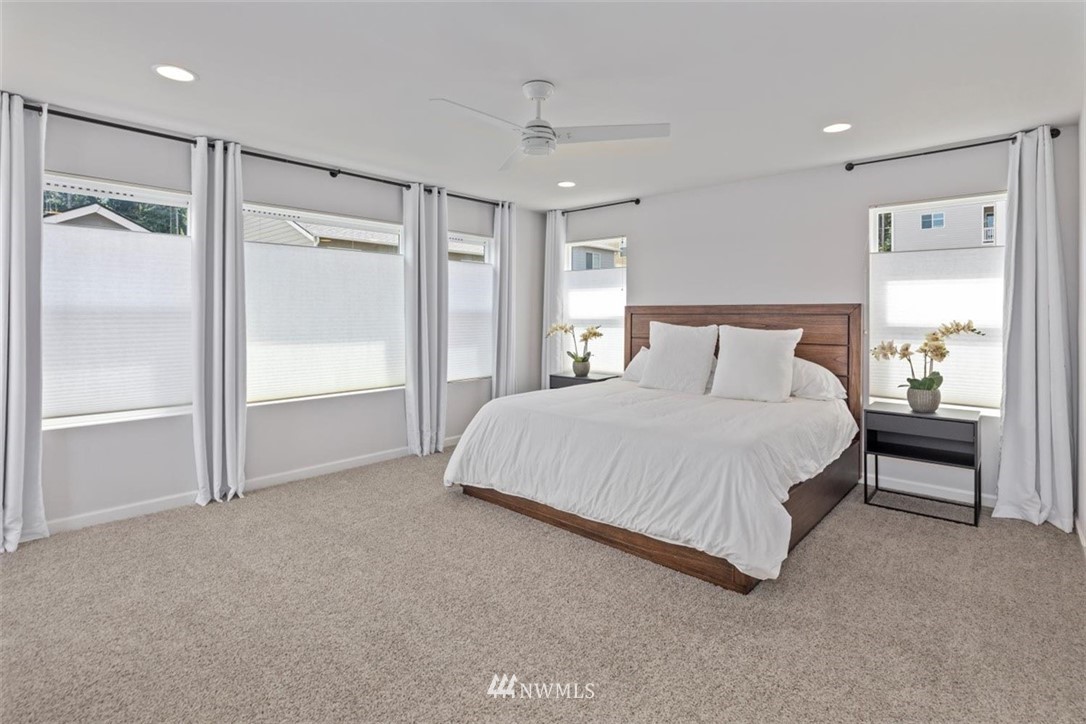 320 181st Street Southeast Bothell, WA 98012 - Photo 22 of 40 a spacious bedroom with a bed and a lamp